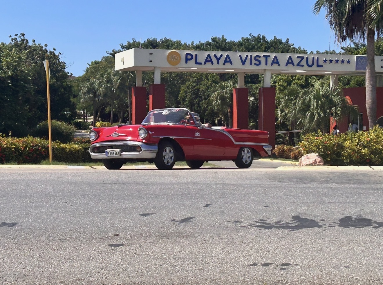Vintage red convertible car in front of the Playa Vista Azul resort entrance in Varadero, Cuba